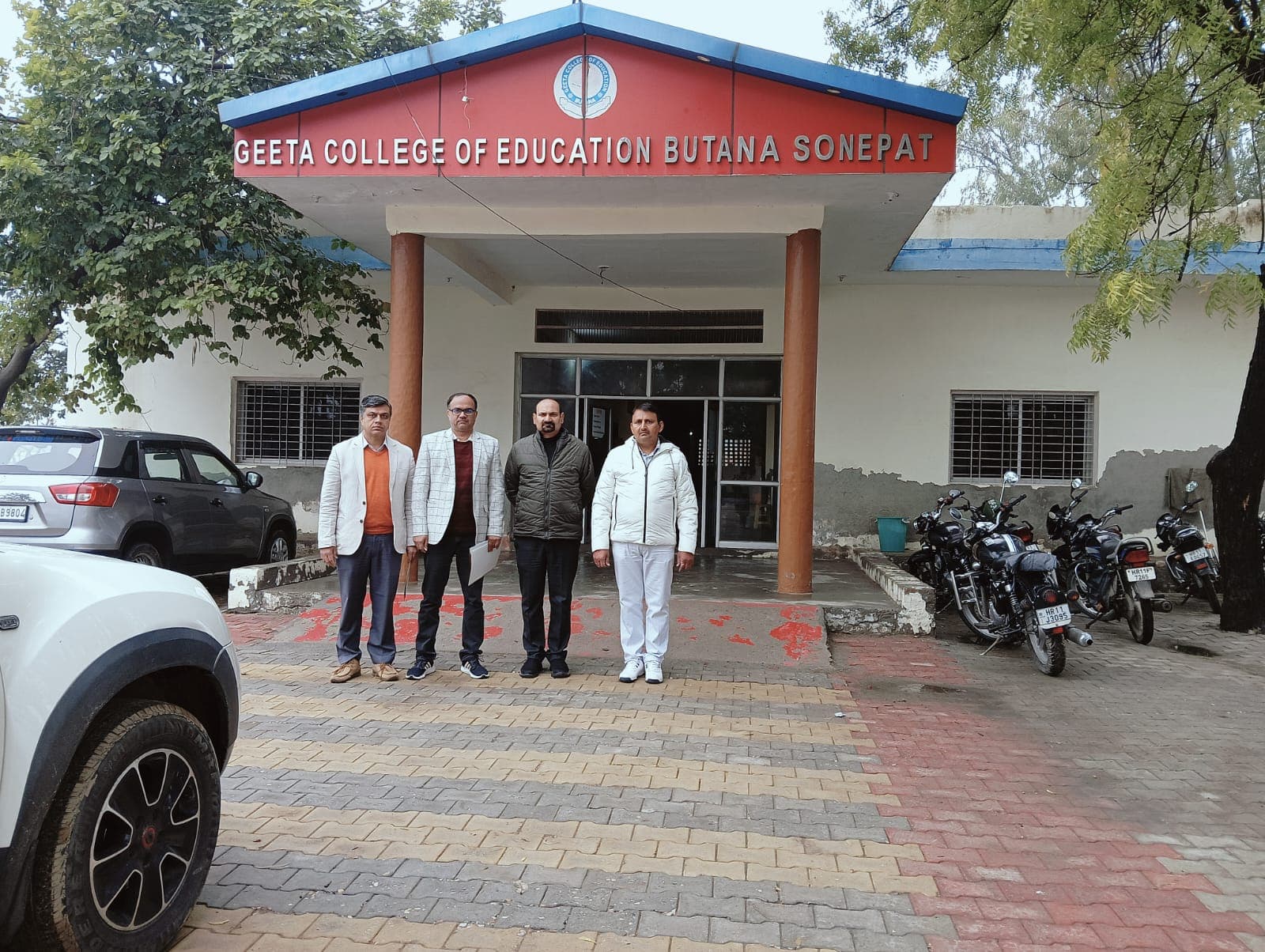 College main entrance, staff standing outside the front porch