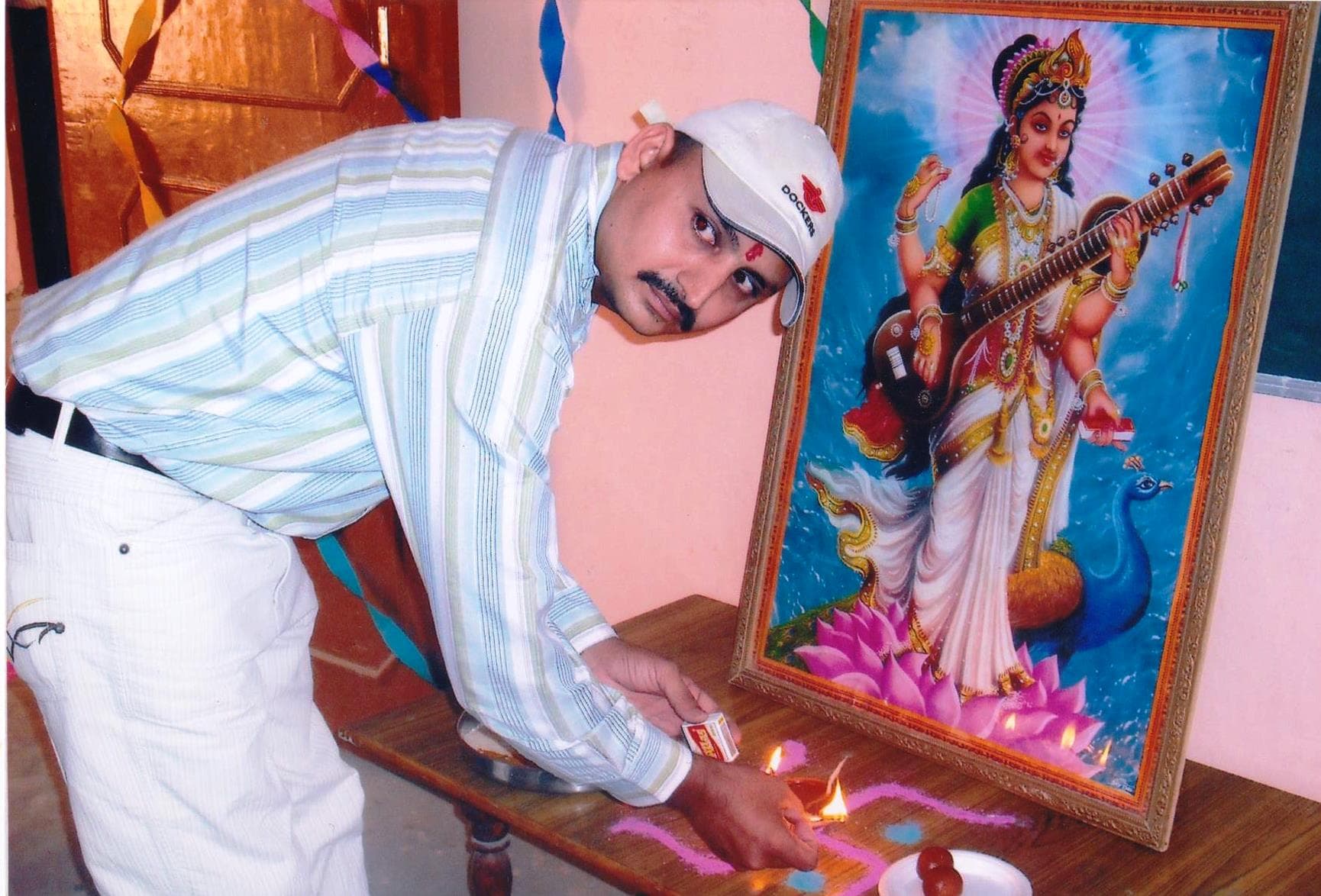 Farewell (Vidaayi) event: lighting a ceremonial lamp before a Saraswati portrait